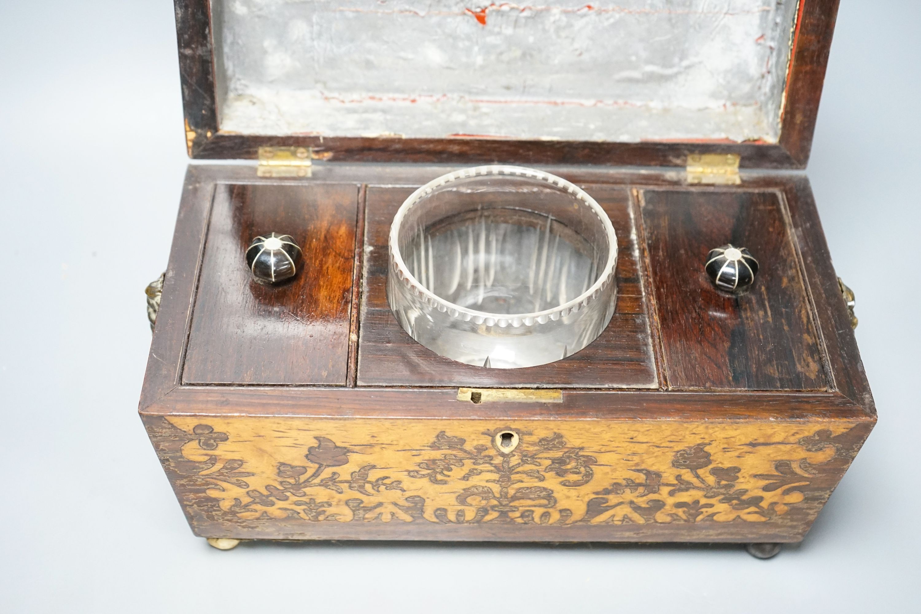 A 19th century rosewood and bird’s eye maple tea caddy, of sarcophagus form, the interior with mixing bowl, on ball feet 31cm